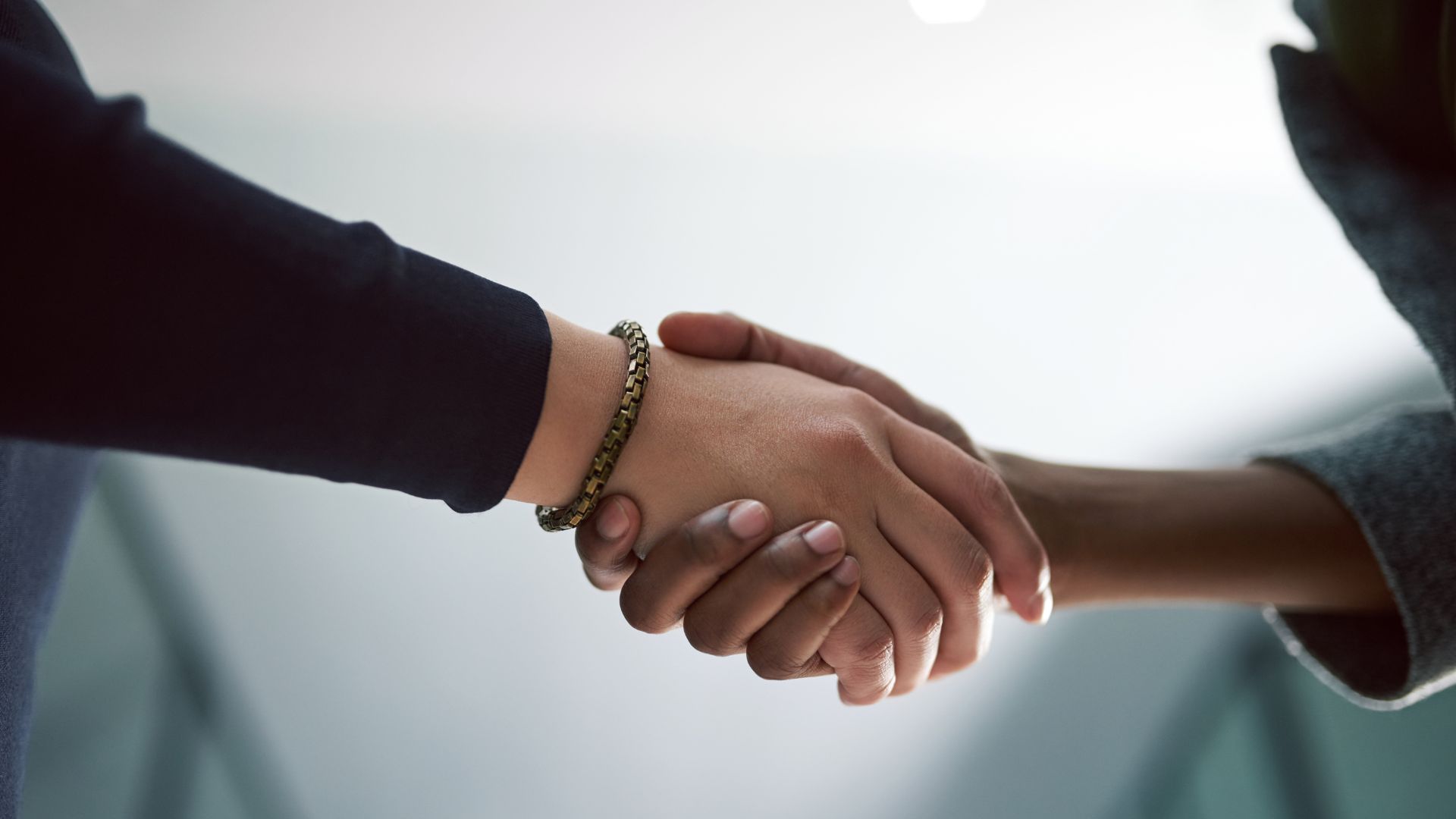 Geste de poignée de main entre deux personnes, symbolisant un accord et une collaboration, en lien avec le respect du RGPD.