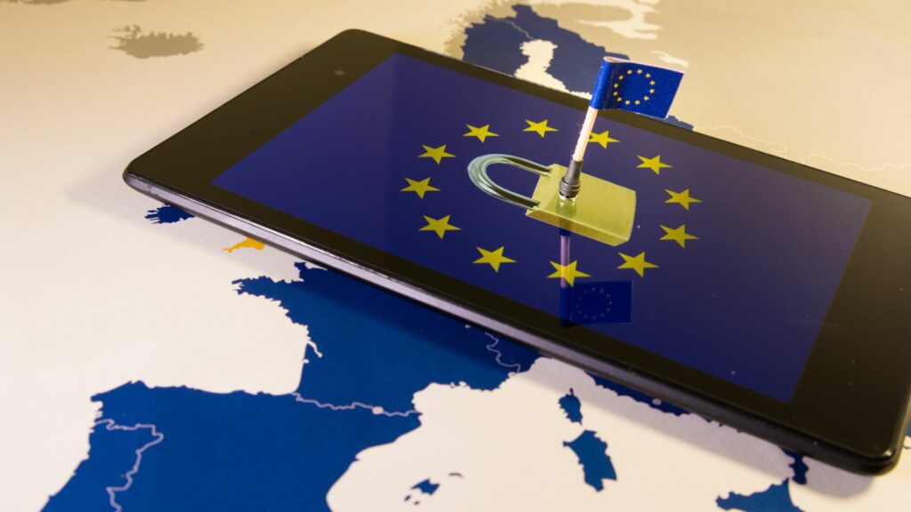 Tablette affichant un cadenas entouré d'étoiles sur fond de drapeau de l'UE, évoquant la protection des données et la cybersécurité au sein de l'Union européenne.